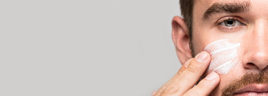 Een man smeert anti aging crème voor mannen op zijn gezicht