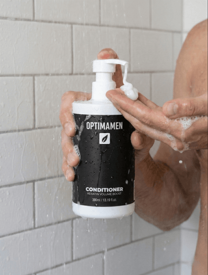 Volume conditioner voor mannen met keratine - 390ml verpakking van OPTIMAMEN voor sterker en dikker haar, gefotografeerd in een luxe badkamer.