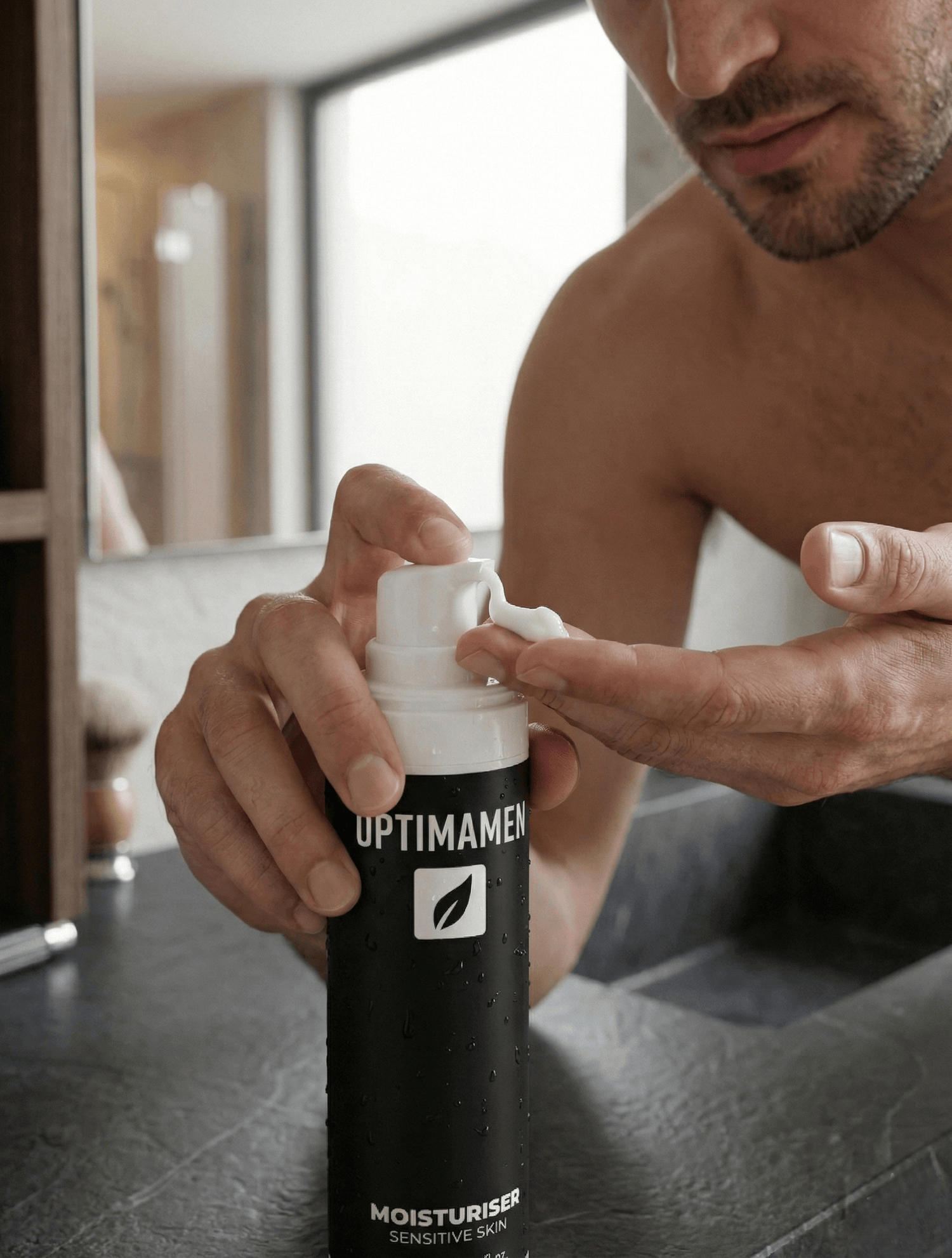Gezichtsverzorging voor de gevoelige mannenhuid: het smeren van een kalmerende moisturizer die irritatie na het scheren voorkomt.